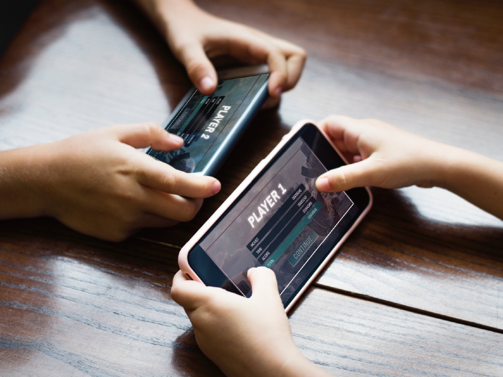 大人小孩同時玩手機遊戲照片